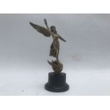 A silver Angel of Peace Victory mascot set on winged wheel holding a feather and a laurel wreath,