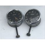 Two black faced Jaeger eight day car clocks.