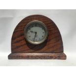 A Smiths silver faced eight day car clock mounted in an oak display.