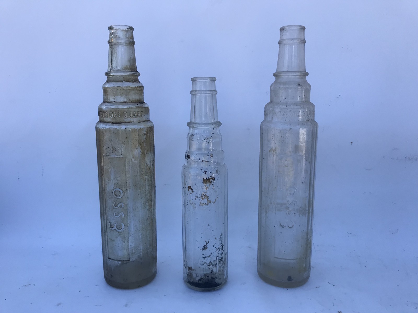 Two Esso quart glass oil bottles and an Essolube pint oil bottle.