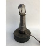 A rare accessory mascot in the form of a lighthouse, with hinged lid and bulb inside for a