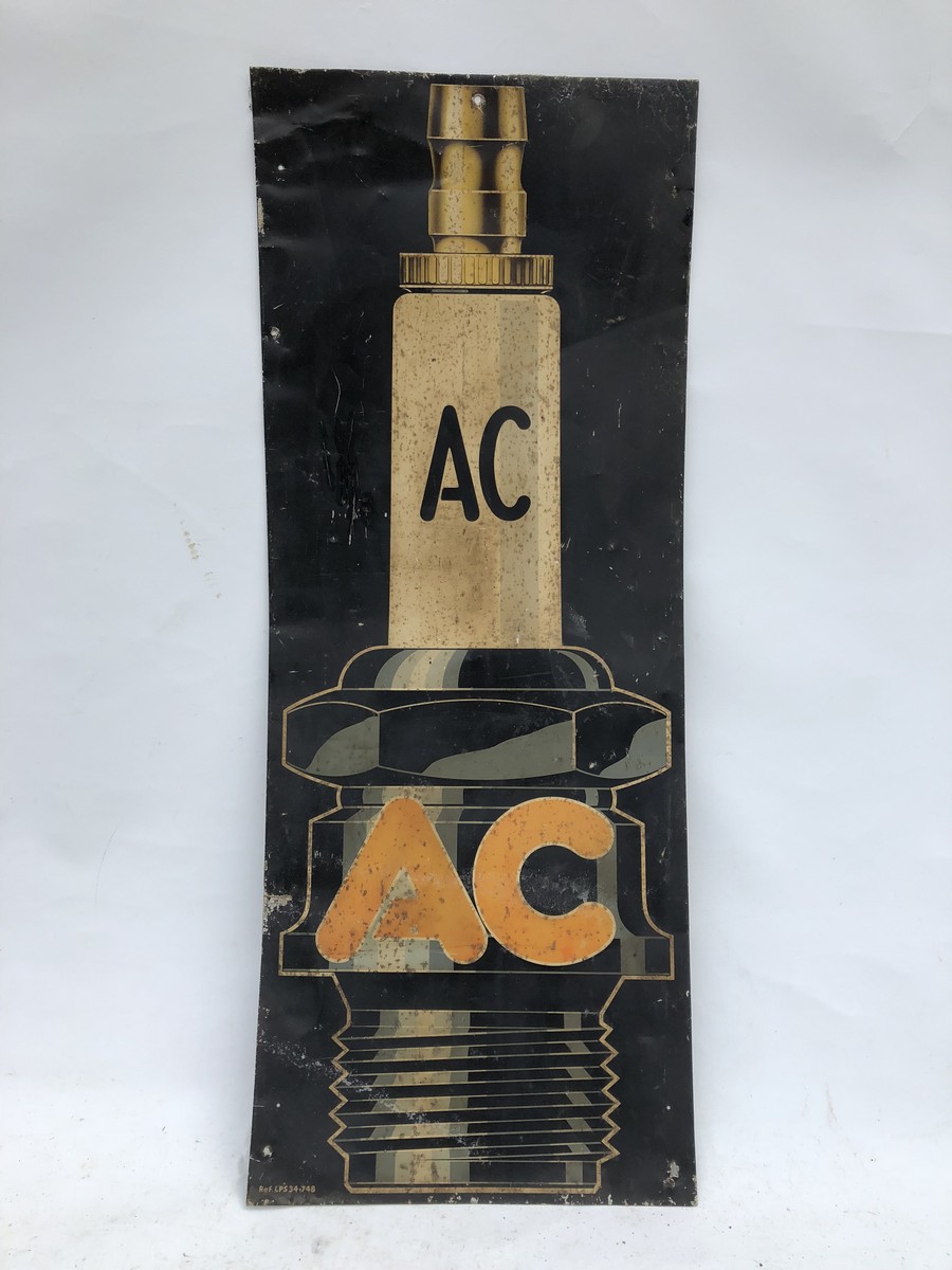 An AC Plugs pictorial tin advertising sign, 11 1/2 x 32".