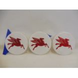 Three circular plastic Mobiloil 'flying Pegasus' roundals, trimmed from a larger sign, each