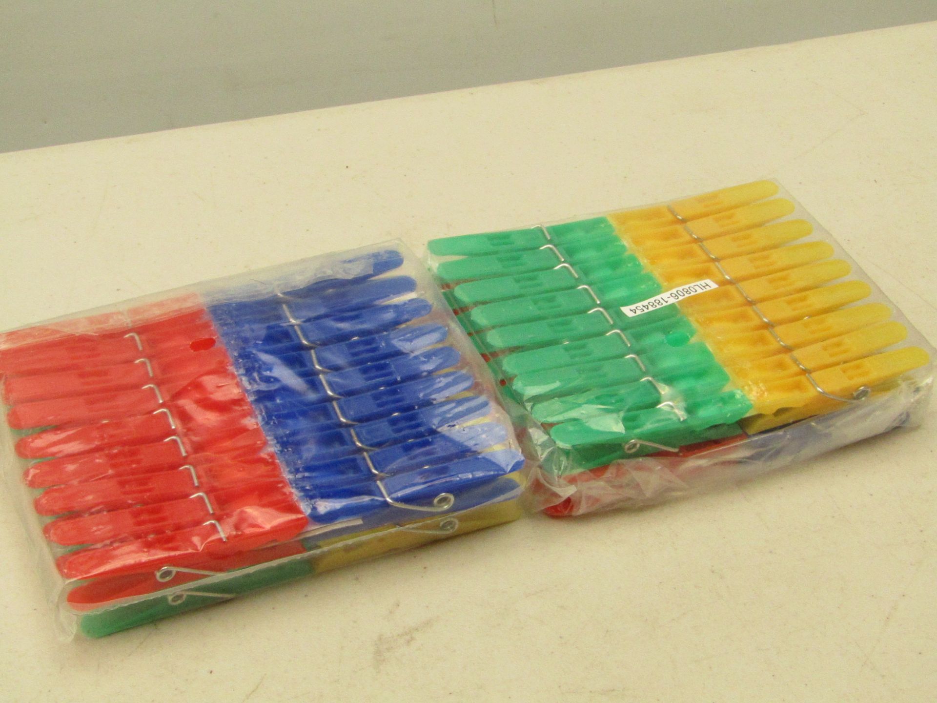 Box containing approx. 40 packs of green, blue, yellow and red clothes pegs. New and boxed.