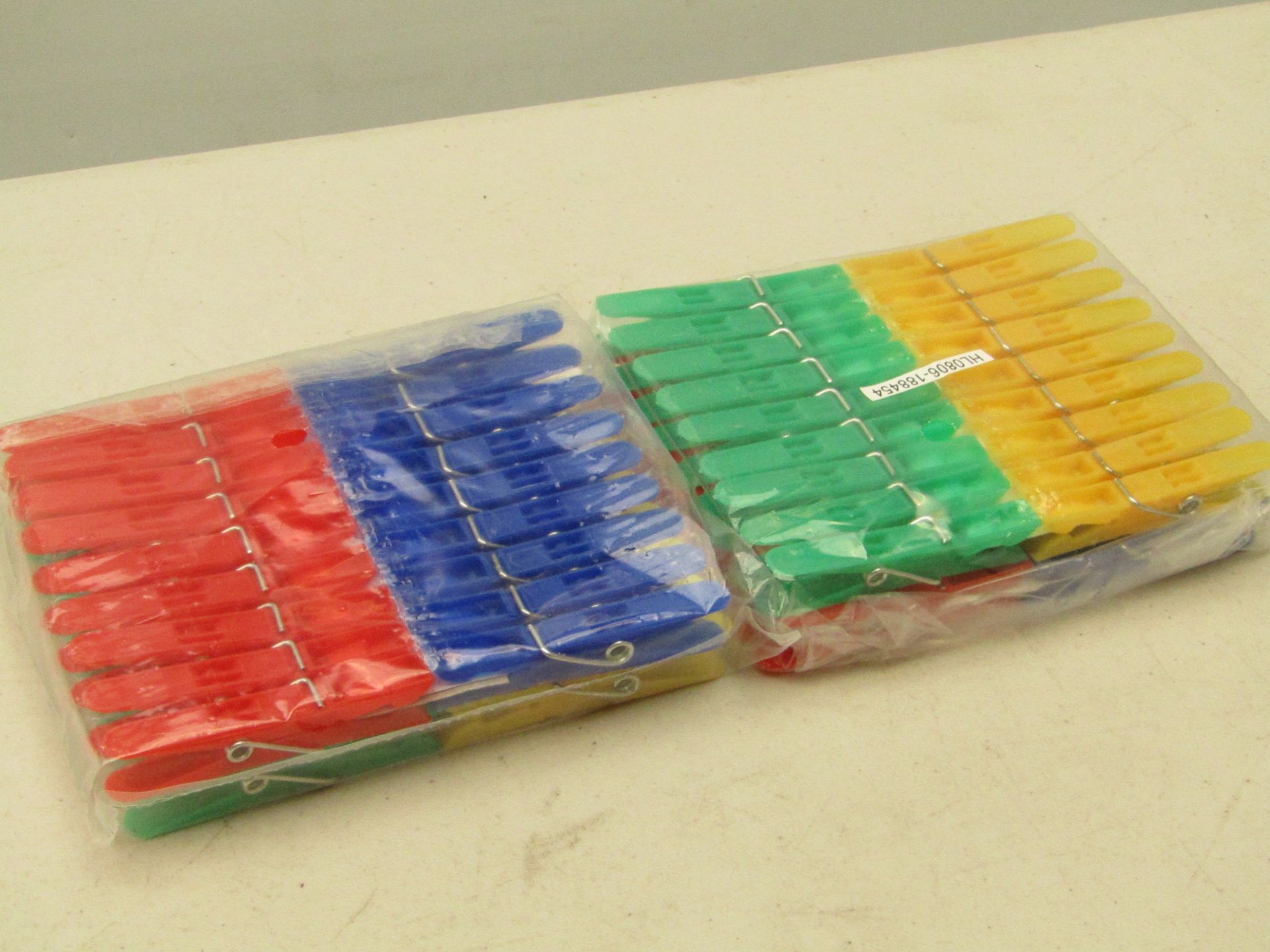 Box containing approx. 40 packs of green, blue, yellow and red clothes pegs. New and boxed.