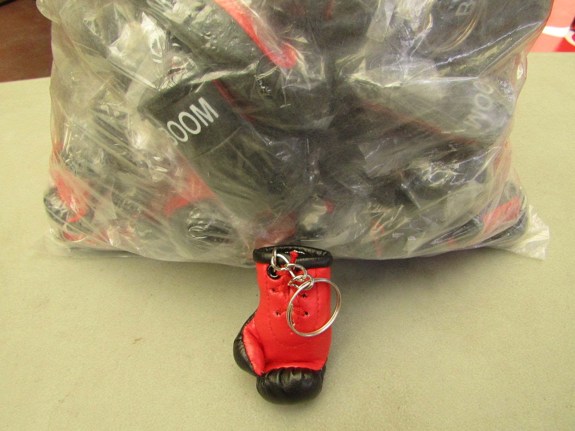 Bag with approx 50 boxing glove keyrings in packaging