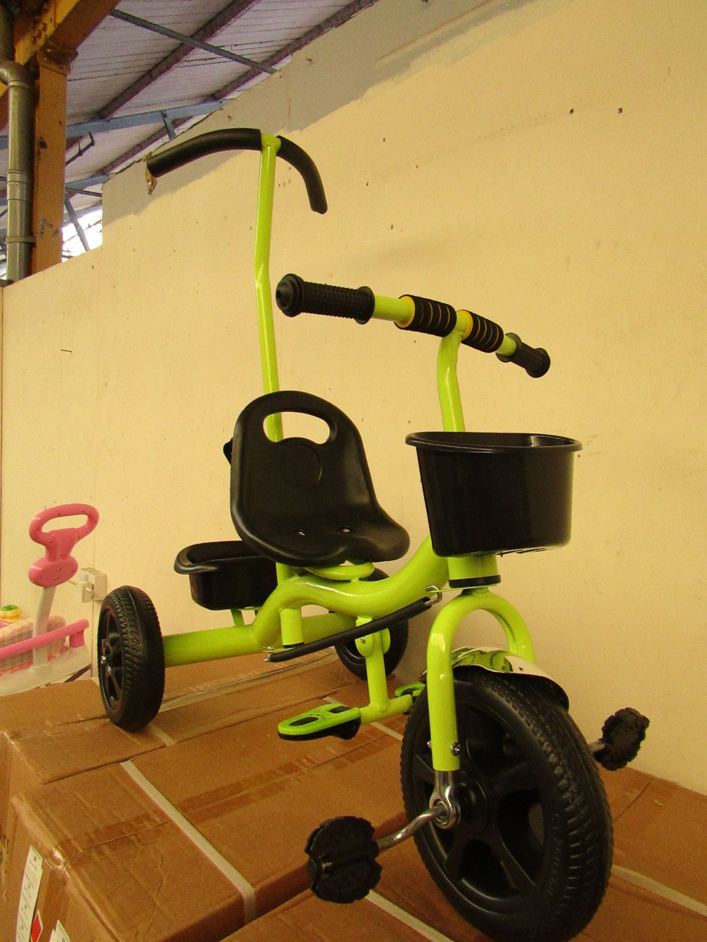 Green colour tricycle with parental control handle. New and boxed.