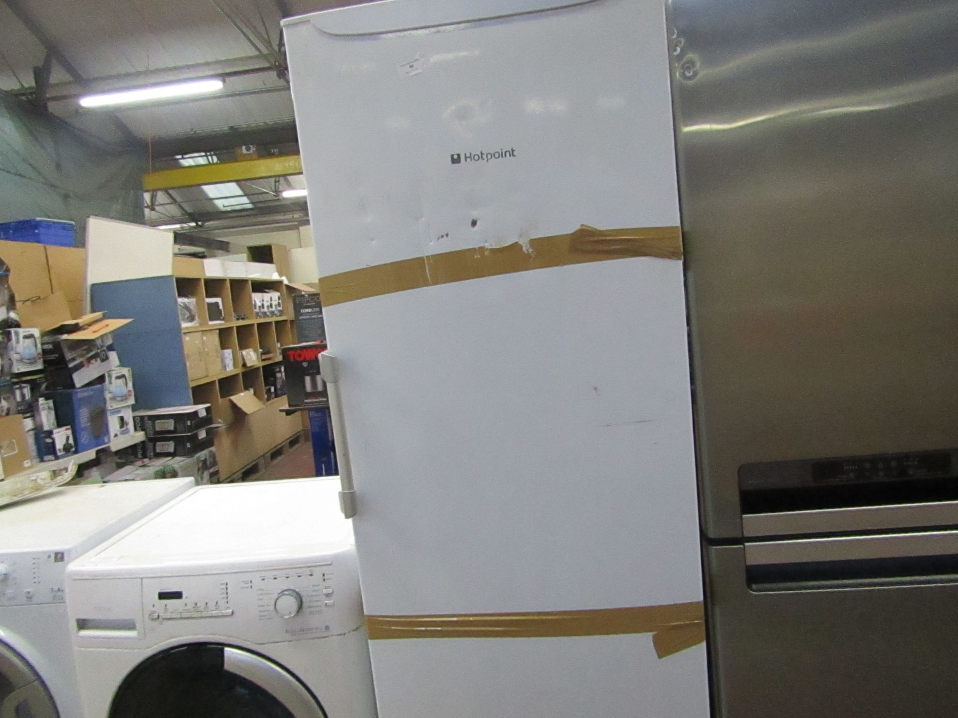 Hotpoint tall freestanding fridge, has damage on the front and is pending condition report.