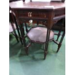 Octagonal ebonised display table with under shelf