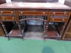 Mahogany sideboard on 8 turned legs to castors with centre drawer flanked by 2 smaller drawers,