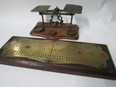 A set of postal scales & a wood mounted brass cribbage board