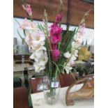 Artificial gladioli in glass vase
