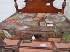 Large vintage leather travel case covered with many international travel labels