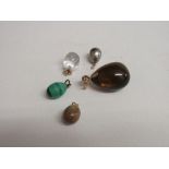 5 gold mounted egg pendants including a rock crystal egg pendant, malachite egg pendant with maker's