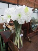 Artificial lilies in large glass vase