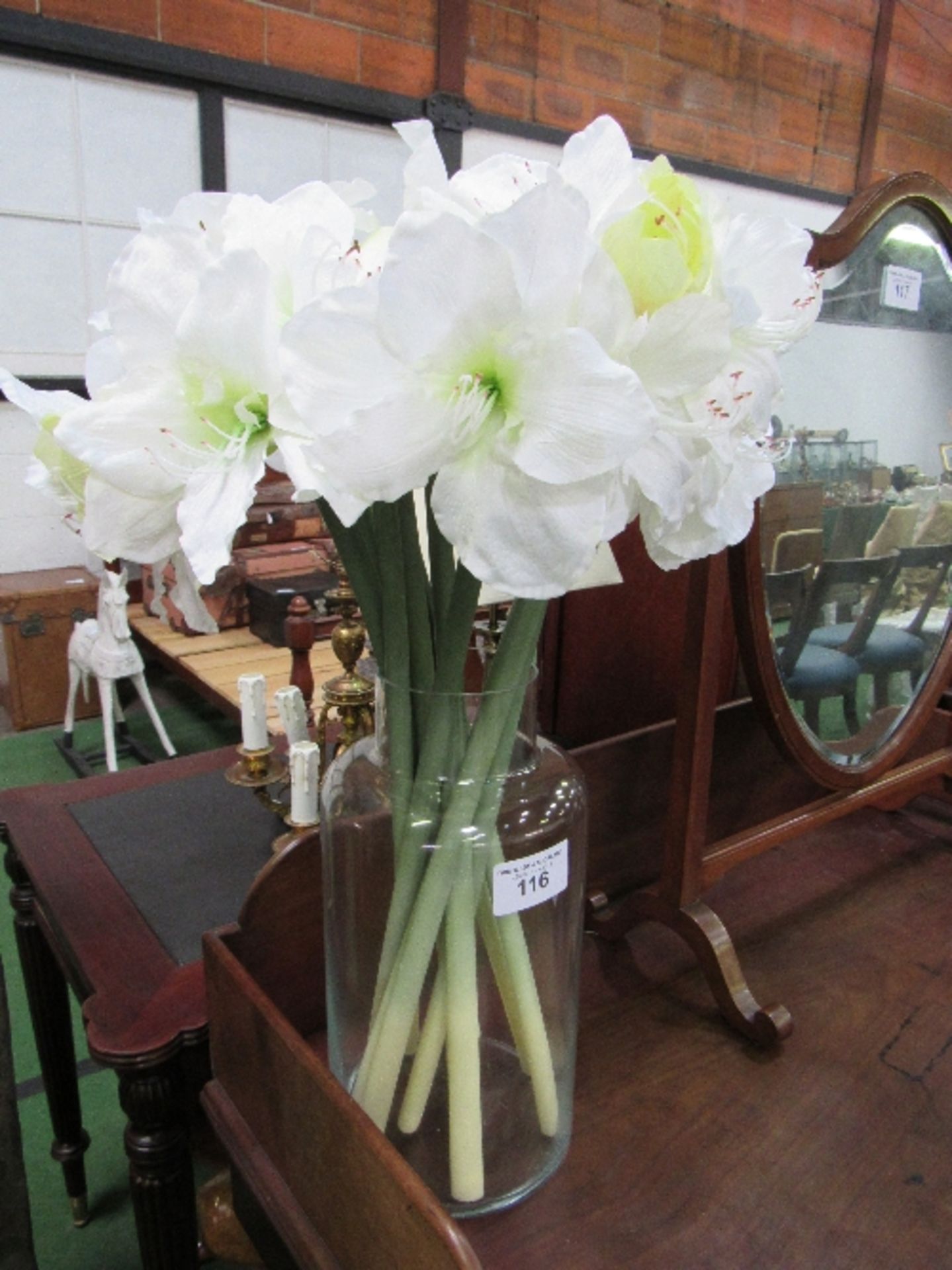 Artificial lilies in large glass vase