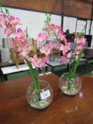 2 artificial pink orchids in glass vases