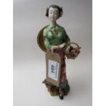 An oriental lady figurine with basket of flowers. Price guide £10-20.