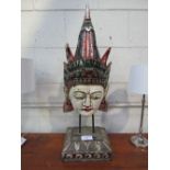 An Asian painted face mask on stand. Price guide £10-20.