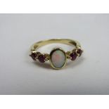 18ct gold ring with opal & flanked by 2 red stones, weight 3.7gms, size P. Price guide £70-100.