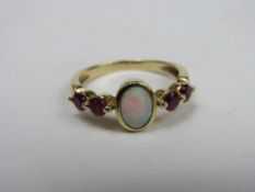 18ct gold ring with opal & flanked by 2 red stones, weight 3.7gms, size P. Price guide £70-100.