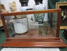 A 'Cyclo-Stormograph' barometer in glass case on a wooden plinth. Price guide £30-40.