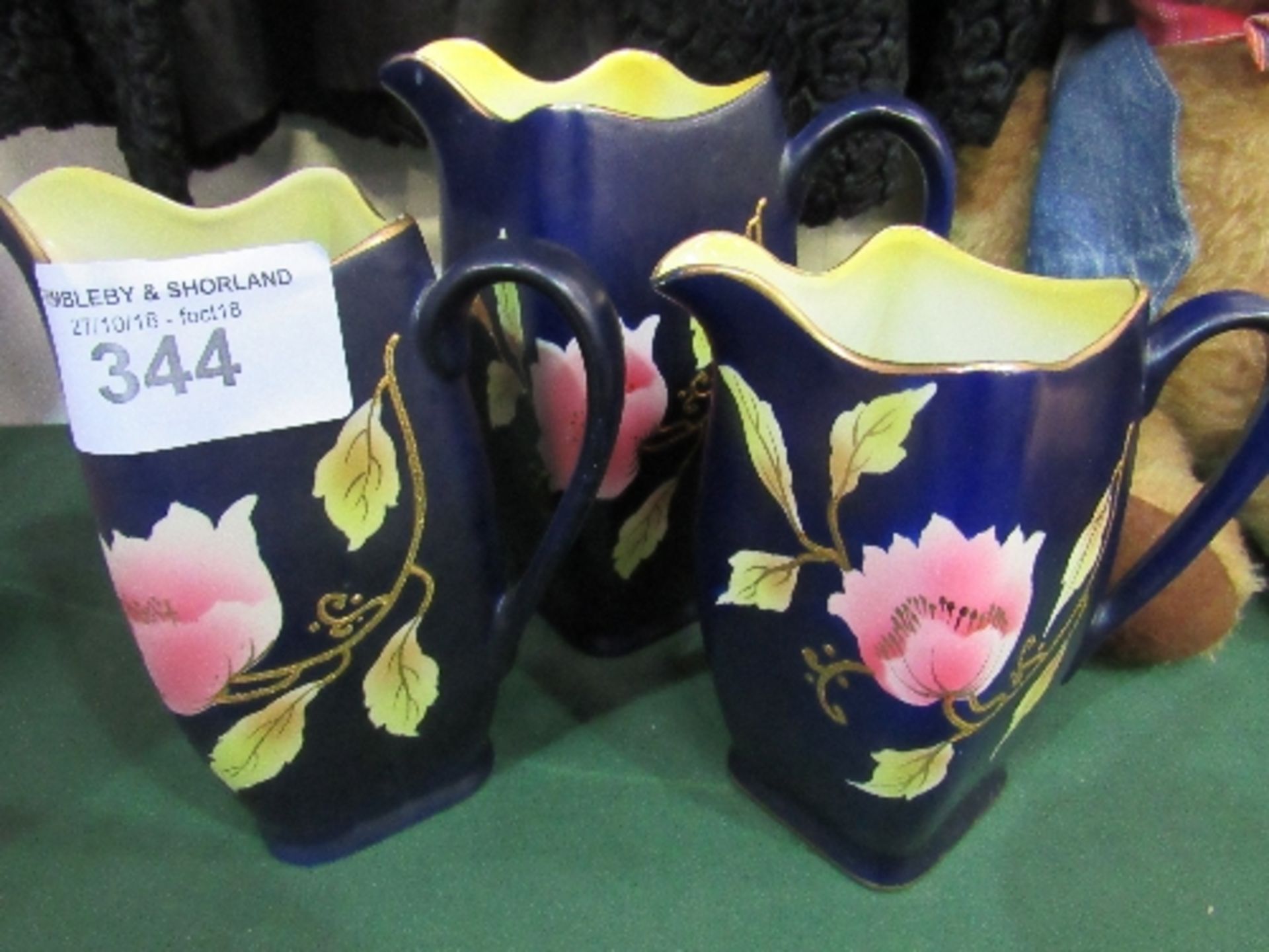 3 graduated jugs, blue with gold rims & flower pattern, 1920's/1930's. Price guide £15-20.