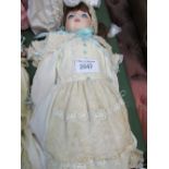 A large porcelain doll in a lace embroidered dress. Price guide £20-30.