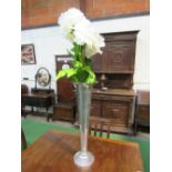 Tall silver metal vase & artificial flowers, 67cms tall. Price guide £10-20.