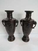 A pair of oriental bronze vases, 31.5cms height. Price guide £150-180.