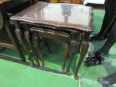 A nest of 3 mahogany glass top tables. Price guide £10-20.