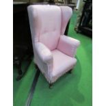 Pink upholstered child's wing back armchair. Price guide £20-30.