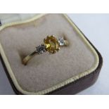 18ct gold ring set with an oval yellow stone (possibly diamond), flanked with diamonds, size Q 1/