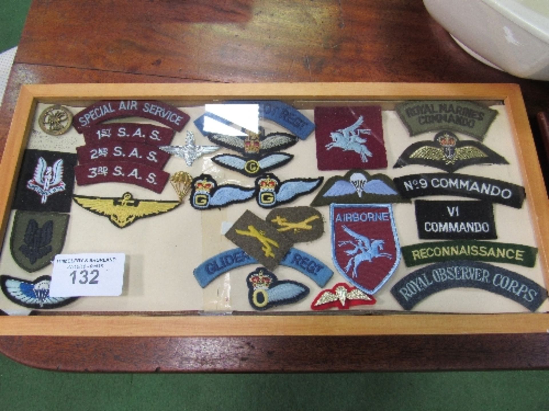 2 framed collections of military badges in fabric. Price guide £10-20.