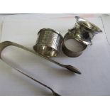 3 silver napkin rings, 2.2ozt & a pair of Georgian silver sugar tongs, 1.6ozt. Price guide £30-40.