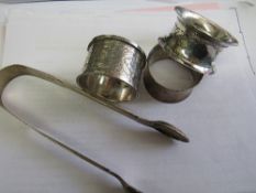 3 silver napkin rings, 2.2ozt & a pair of Georgian silver sugar tongs, 1.6ozt. Price guide £30-40.