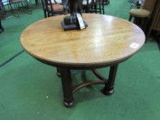 Circular oak table on 4 block legs with curved stretchers, 9cms diameter x 60. Estimate £50-100.