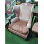 Pink upholstered wing back armchair. Estimate £20-30.