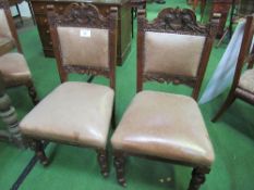 6 carved mahogany framed leather upholstered dining chairs on casters. Estimate £30-50.