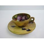 Royal Worcester tea cup and saucer. The tea cup has a plain gilt exterior with painted fruit inside,