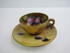 Royal Worcester tea cup and saucer. The tea cup has a plain gilt exterior with painted fruit inside,