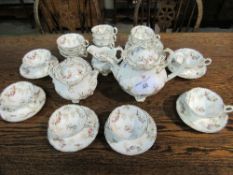 Cream & gold part tea service with floral decoration. Estimate £10-20.