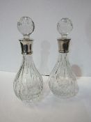 A matched pair of lead crystal decanters with silver hallmarked collars in their original