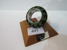 Manor Formula 1 racing team competition wheel nut mounted on a wooden plinth. Estimate £20-40.