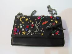 Original Yves St. Laurent, Paris, jewel encrusted wallet evening bag in box. Estimate £100-150.