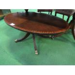 Mahogany oval top coffee table on centre pedestal to casters, 112cms x 67cms x 48cms. Estimate £10-