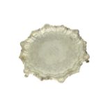 Salver in argento finemente cesellato sostenuto da tre piedini con bordo a più volute e dedica in