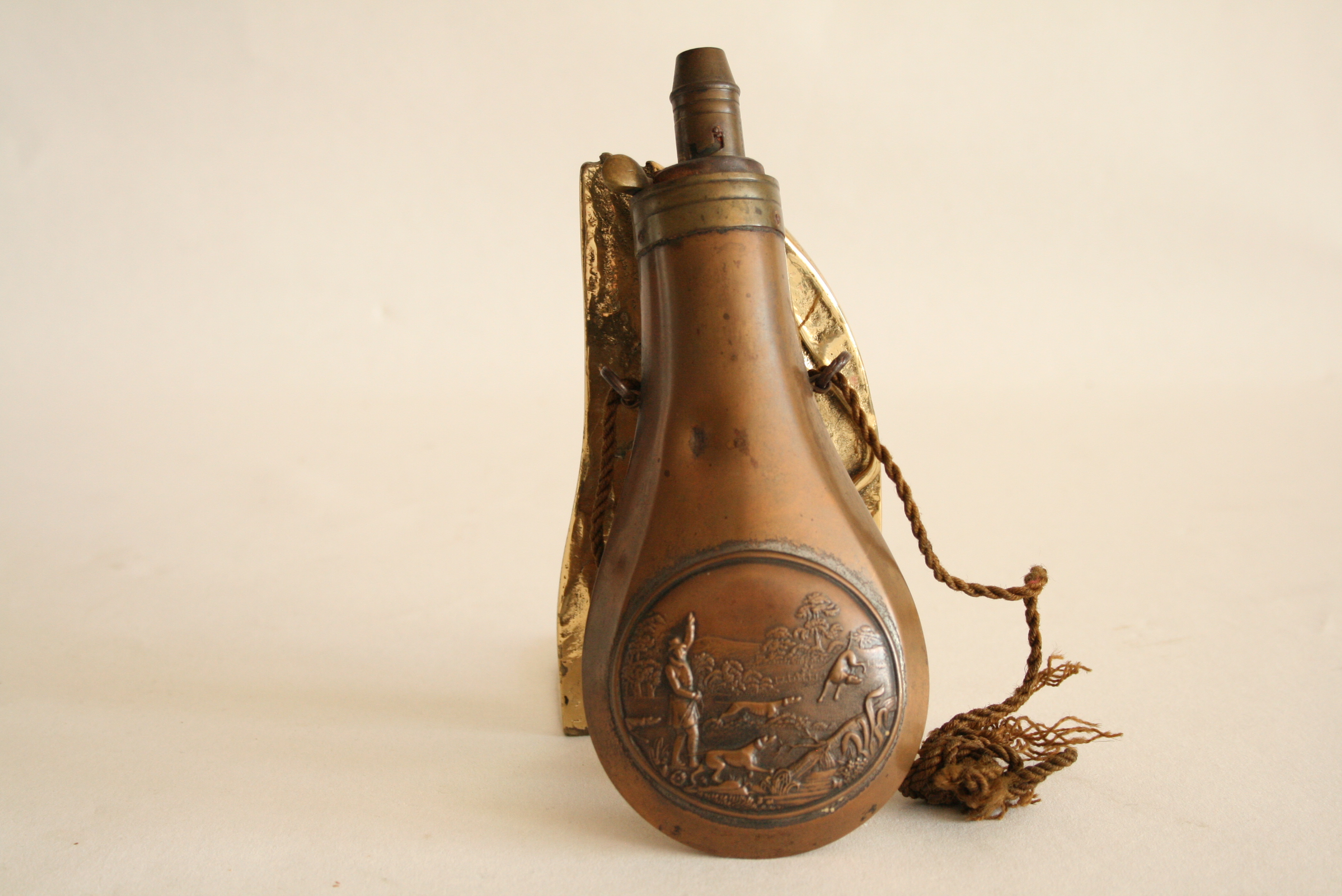 Poire à poudre en cuivre repoussé gravée d'un motif de chasse - - Pear powder in [...]