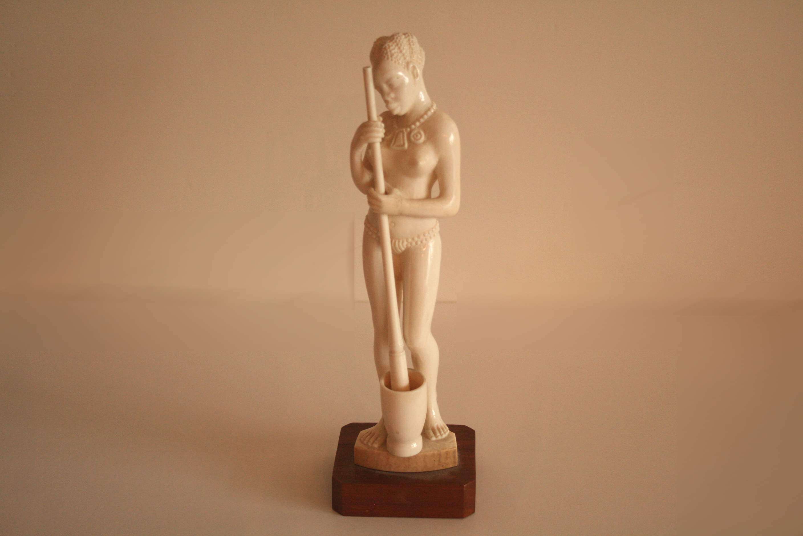 Statuette en ivoire figurant une femme pilant le mil, monogramme A.N. au dos, travail [...]