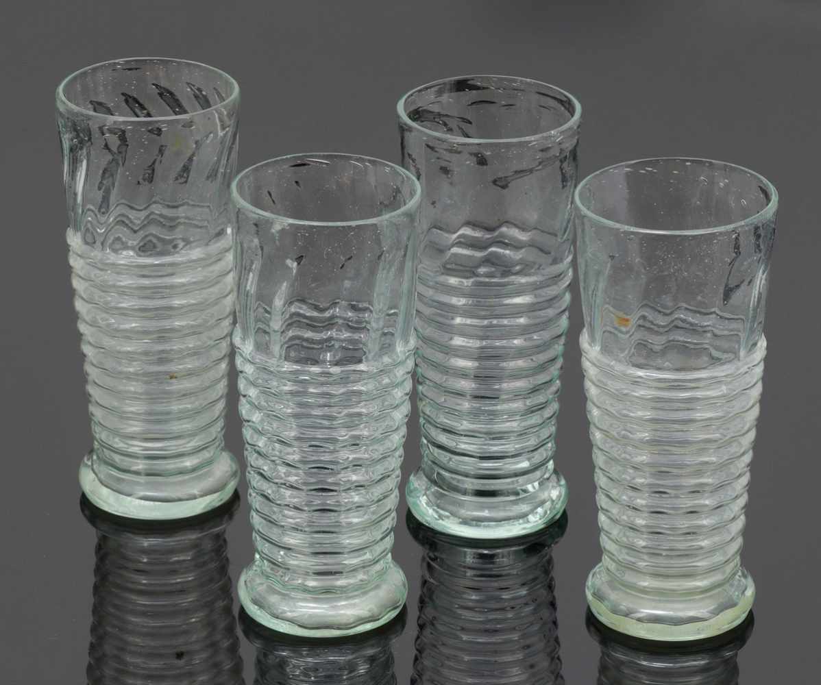 4 Fußbecher Um 1840. Farbloses Glas. Schräg optisch gerippt, mit Wulsten. Abriss. H. 15,5 cm.